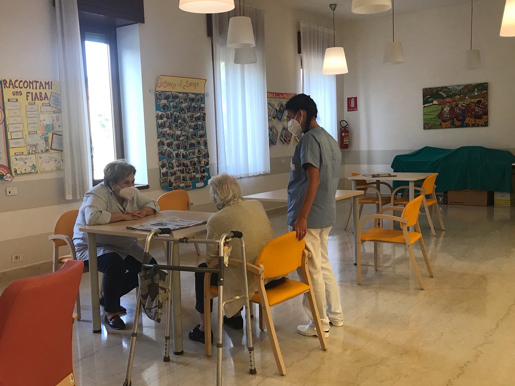 Operatrice di Fondazione Oasi con due ospiti.