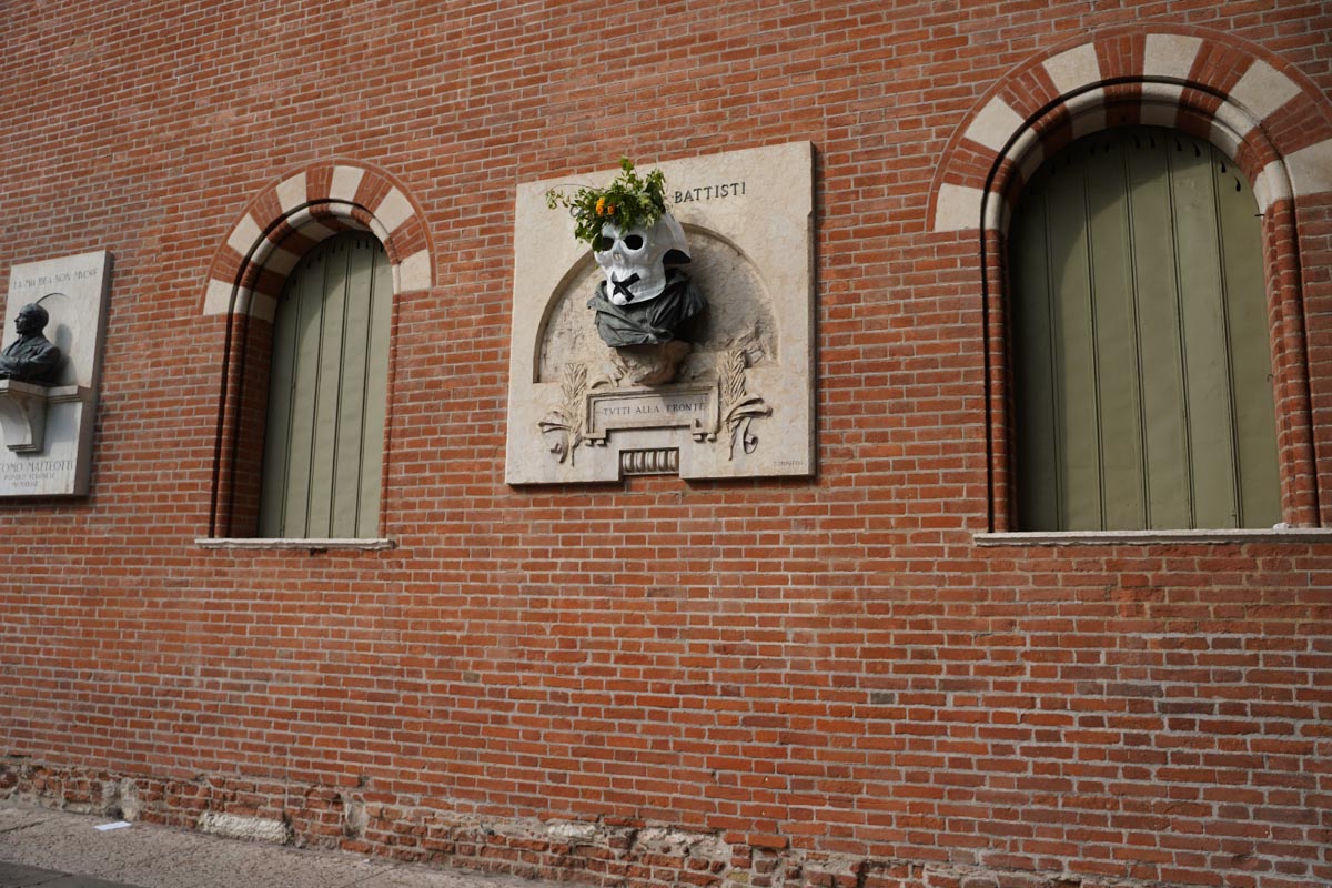 Il busto di Cesare Battisti su piazza Indipendenza, "mascherato"