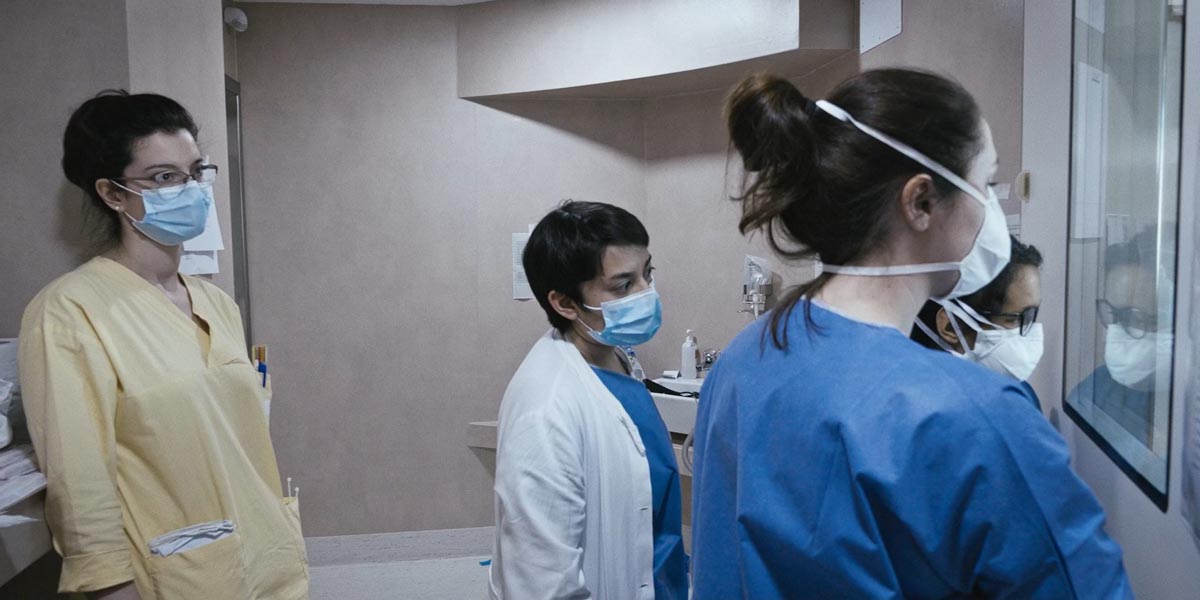 Il personale degli Infettivi assiste con preoccupazione a un delicato intervento dall_esterno di una stanza in cui è ricoverata una paziente che si sta aggravando