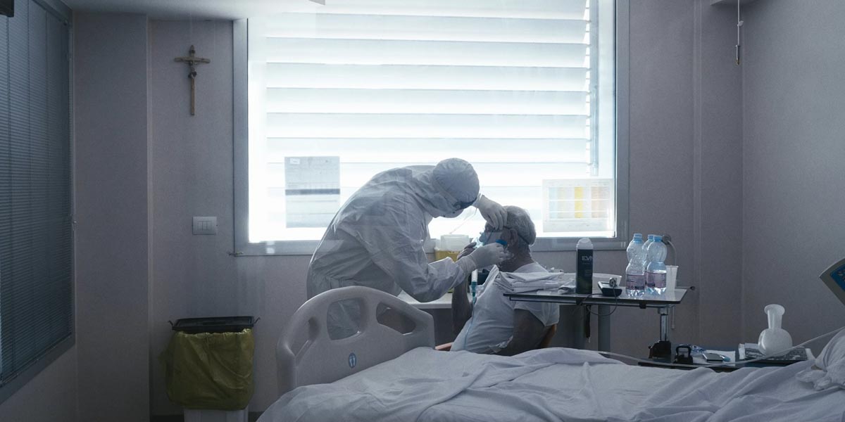 Il sig. Elio si fa radere la barba da un operatore della delegazione albanese, nel reparto di Malattie Infettive