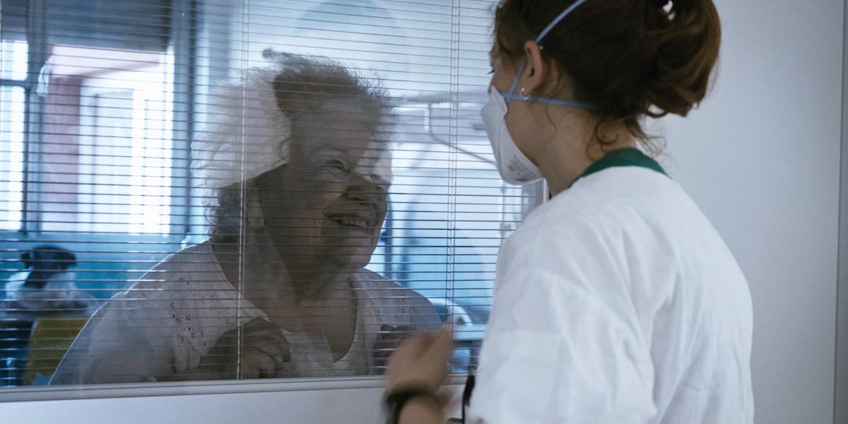 La sig.ra Giusy tenta di parlare con l_infermiera Noemi dalla sua stanza isolata, nel reparto di Malattie Infettive