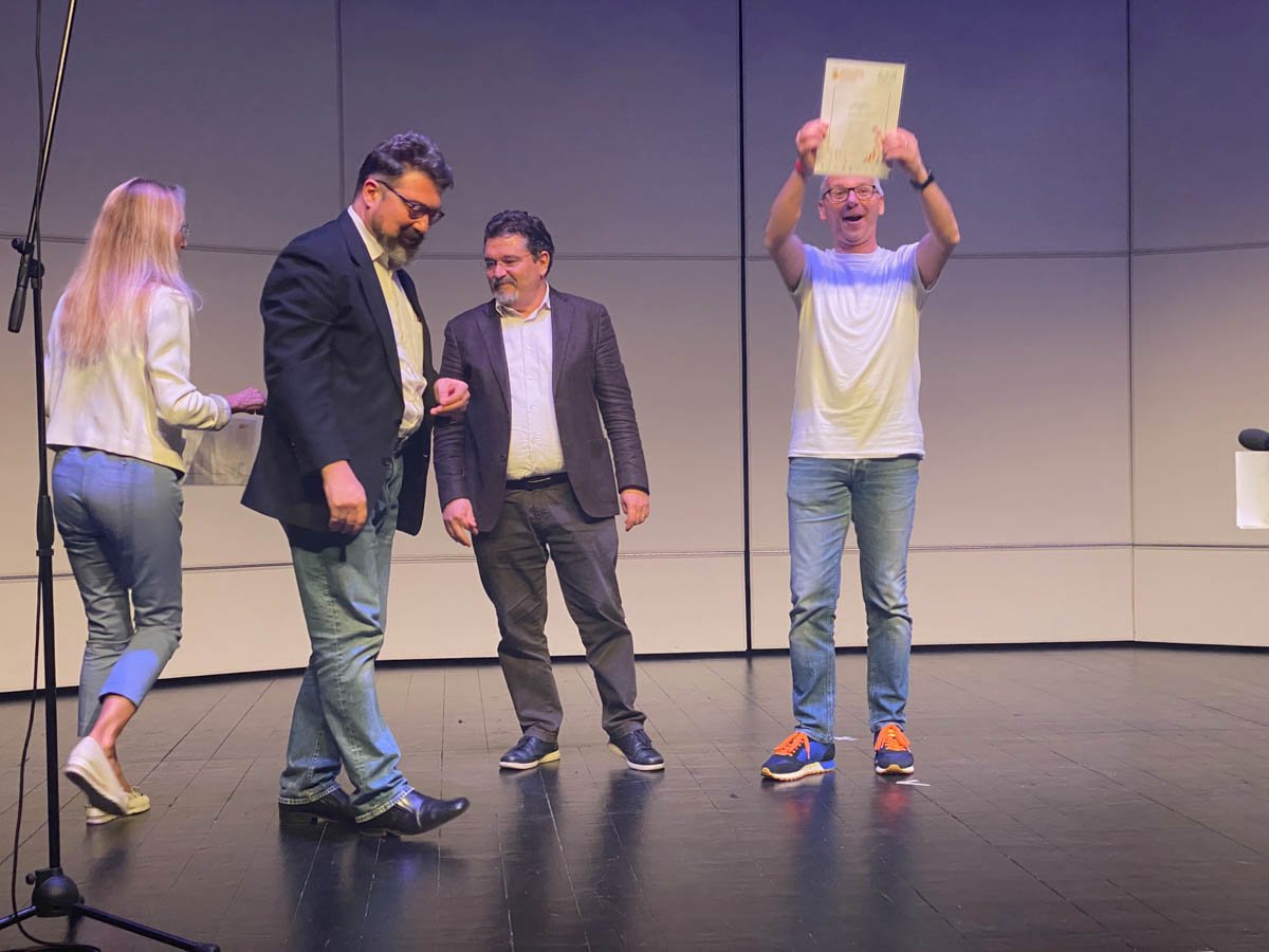 Miko Zamperini, direttore del coro di Cerro Veronese, solleva il premio del Concorso Nazionale Corale “Trofei Città di Vittorio Veneto”