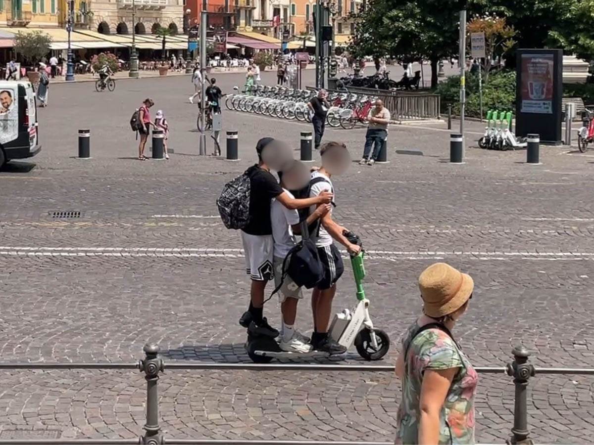 Tre giovani sullo stesso monopattino in piazza Bra a Verona (25 giugno 2025)